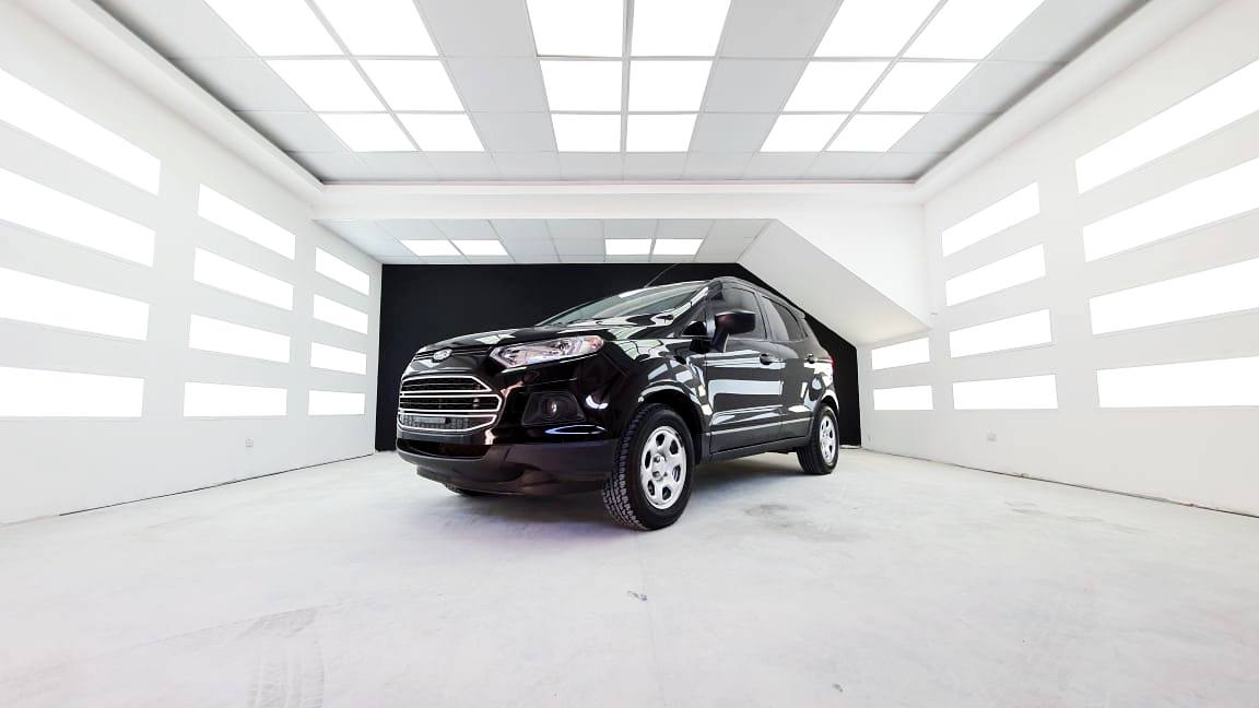 Shiny black vehicle in the center of brightly lit showroom at RestorFX Tandil with light panels